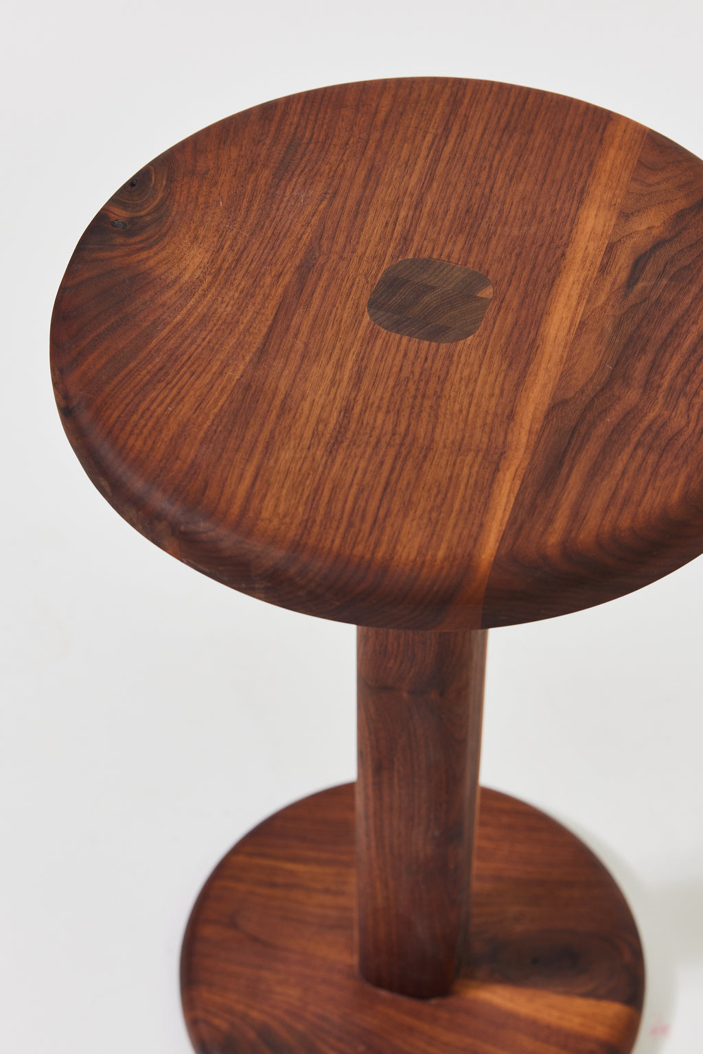 Florian Side Table with large top in solid walnut, detail view 3. Handmade round wooden pedestal side table by Phillip's Daughter