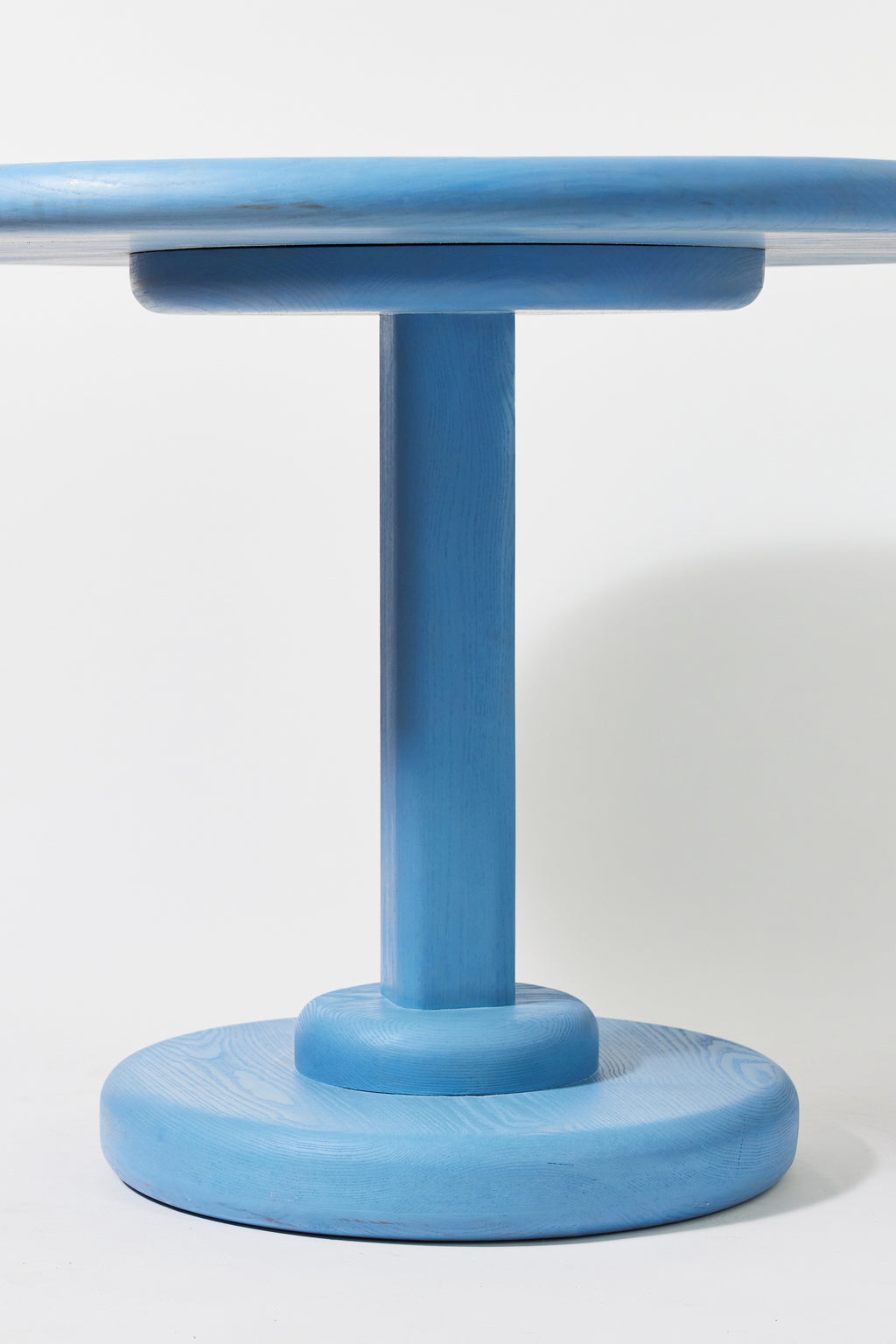 Gumdrop Pedestal Table in Light Blue Ash, detail view 3. Handmade 40 inch round solid ash pedestal dining table by Phillip's Daughter