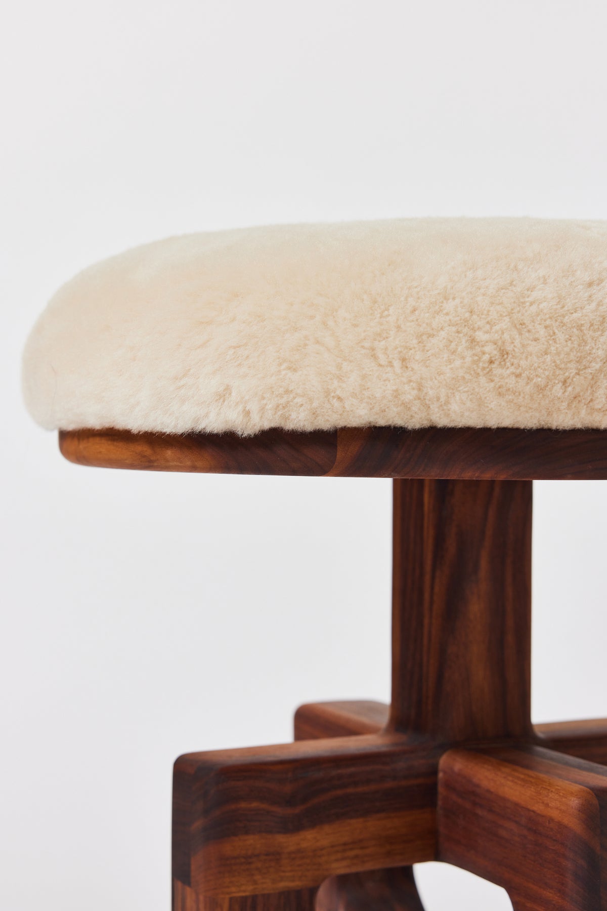Muffin Man Tall stool in solid walnut with putty shearling seat, alternate view. Handmade tall solid wood stool with shearling seat by Phillip's Daughter