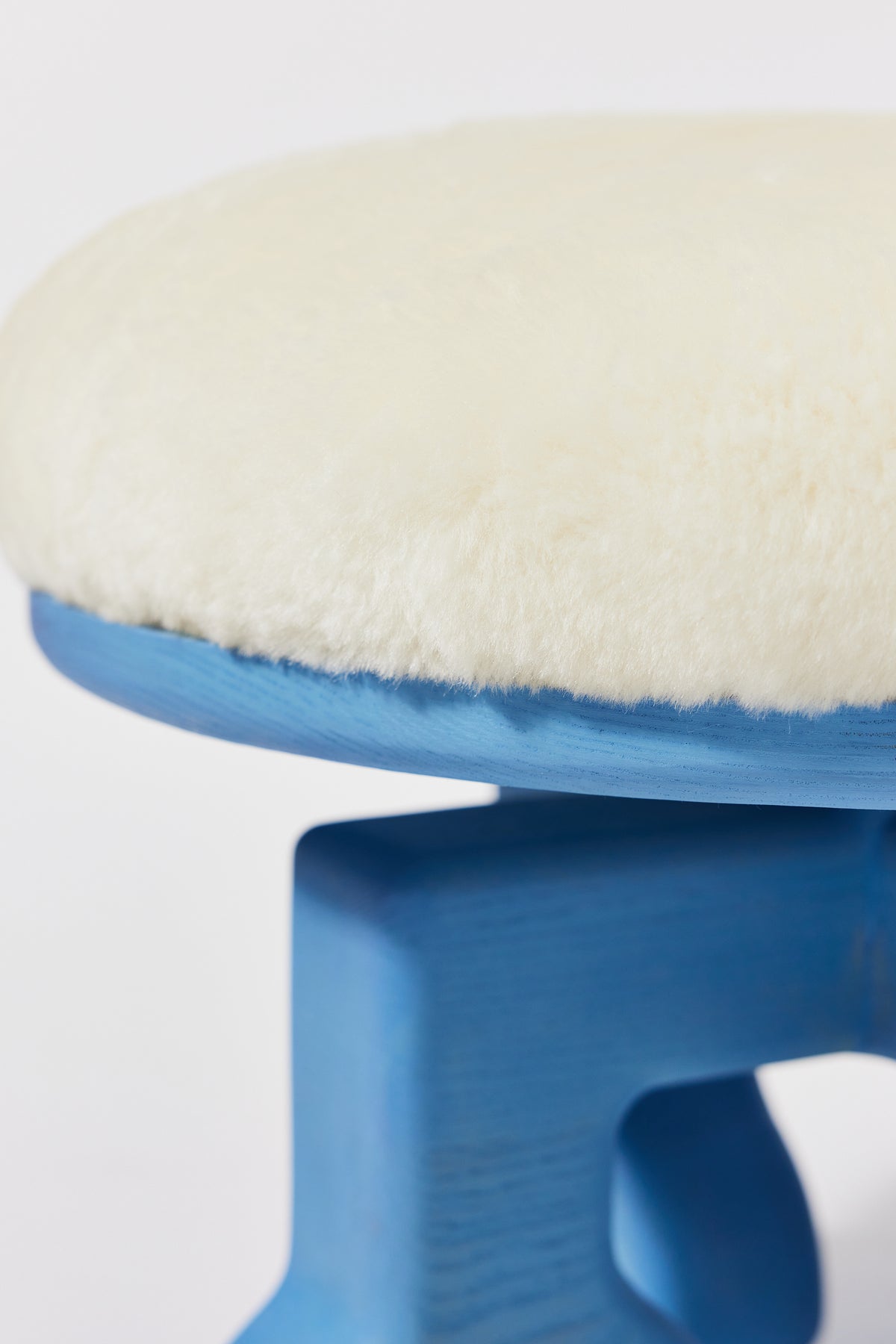 Muffin Man Stool in Light Blue Ash with white shearling seat, alternate view. Handmade solid wood stool with shearling seat by Phillip's Daughter