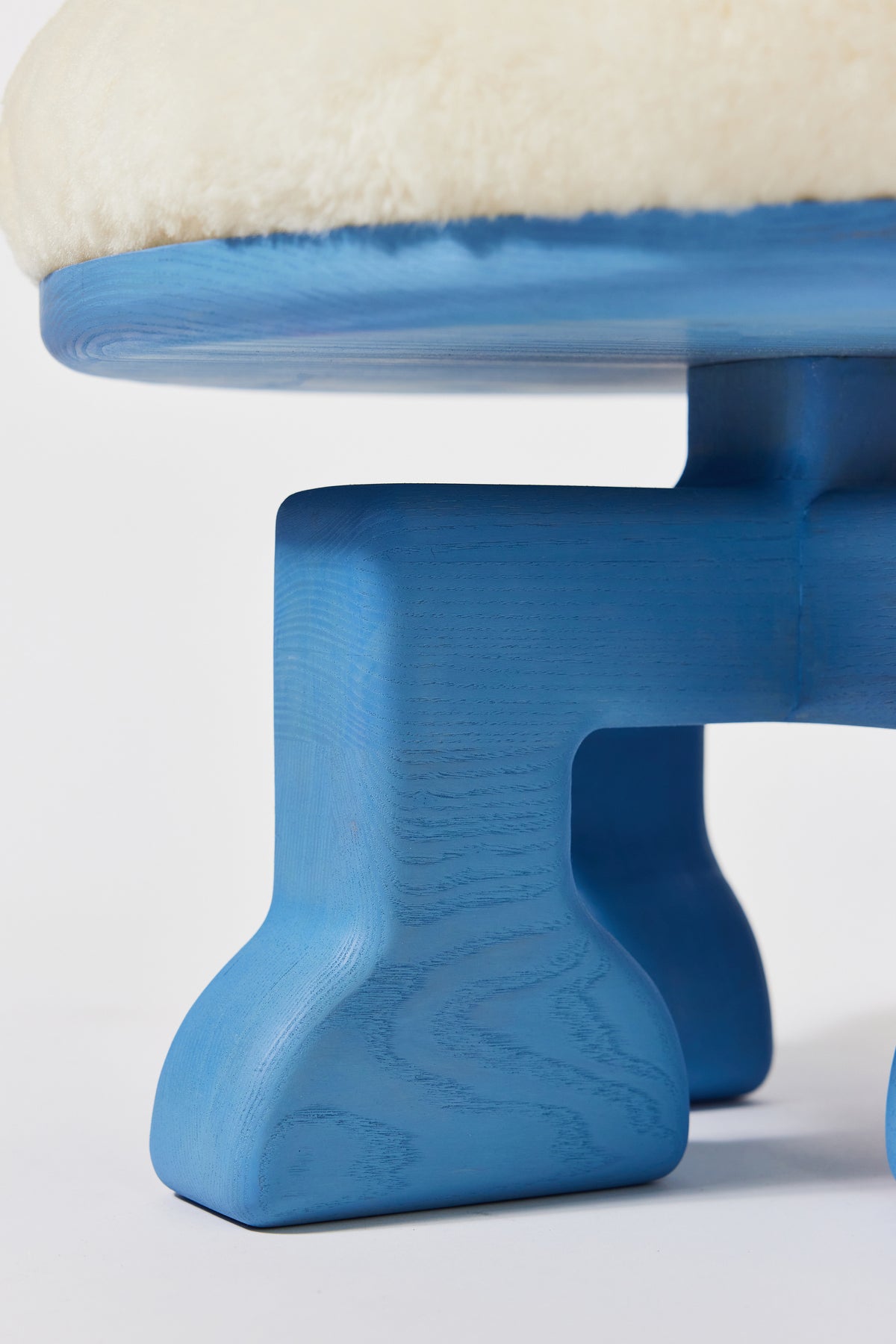 Muffin Man Stool in Light Blue Ash with white shearling seat, detail view 3. Handmade solid wood stool with shearling seat by Phillip's Daughter