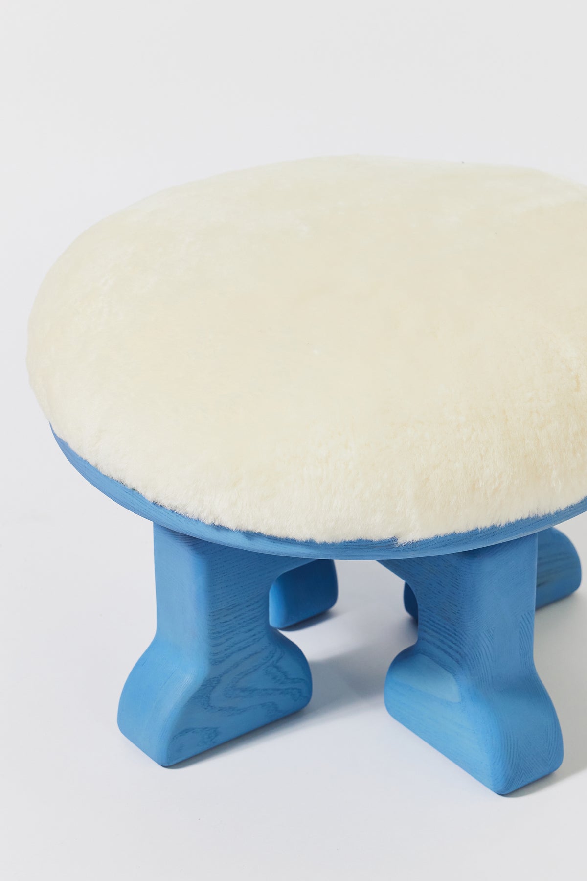 Muffin Man Stool in Light Blue Ash with white shearling seat, detail view 2. Handmade solid wood stool with shearling seat by Phillip's Daughter